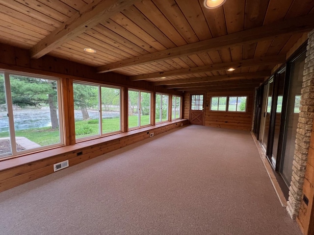 unfurnished sunroom featuring beamed ceiling, wood ceiling, wooden walls, carpet, and recessed lighting