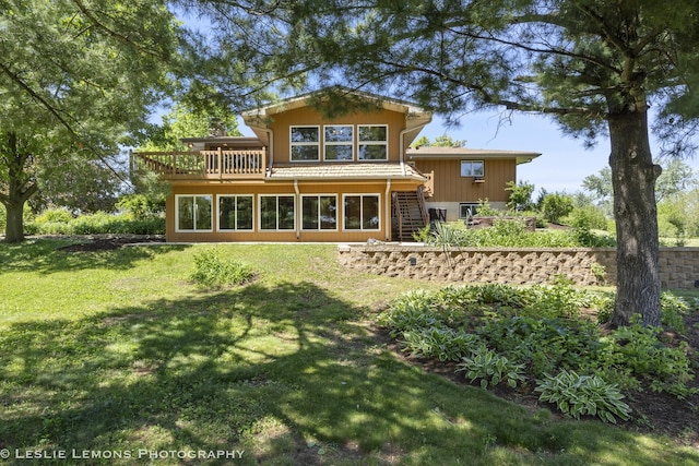 rear view of property featuring stairway, a lawn, and a wooden deck