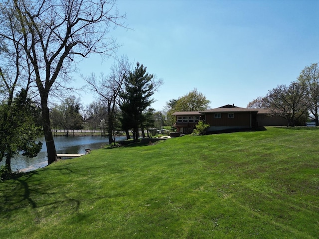 view of green lawn with a water view