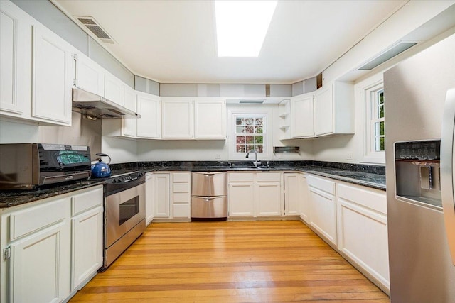 408 W Iowa St, Urbana, IL 61801 - kitchen featuring appliances with stainless steel finishes, under cabinet range hood, open shelves, light wood-style flooring, and white cabinets
