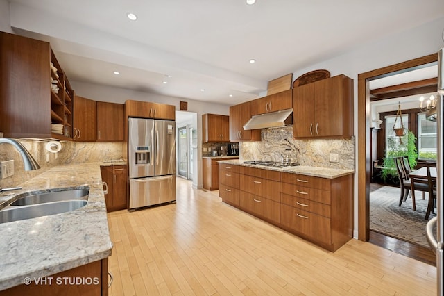 1431 Noyes St, Evanston, IL 60201 - kitchen featuring appliances with stainless steel finishes, a sink, open shelves, under cabinet range hood, and light stone counters
