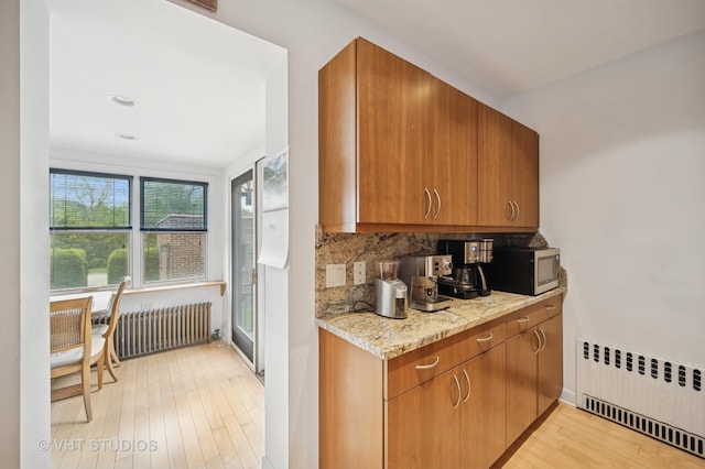 1431 Noyes St, Evanston, IL 60201 - kitchen with radiator, radiator heating unit, light wood finished floors, tasteful backsplash, and stainless steel microwave