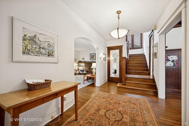 1431 Noyes St, Evanston, IL 60201 - foyer featuring arched walkways, stairs, dark wood-style flooring, and baseboards