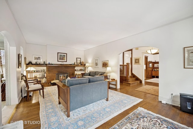 1431 Noyes St, Evanston, IL 60201 - living area with arched walkways, wood finished floors, a brick fireplace, and stairway