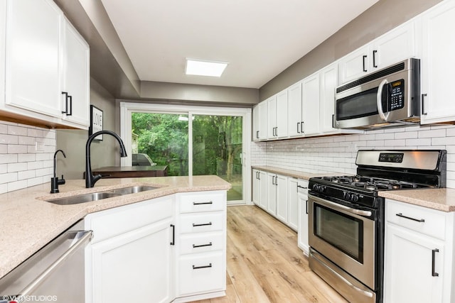 30W012 Laurel Ct, Warrenville, IL 60555 - kitchen with appliances with stainless steel finishes, a sink, light wood-type flooring, and white cabinets