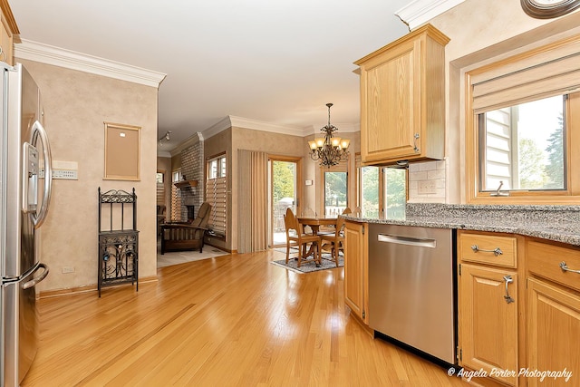 8720 Galleria Ct, Spring Grove, IL 60081 - kitchen featuring appliances with stainless steel finishes, light wood-style flooring, a chandelier, crown molding, and light stone counters