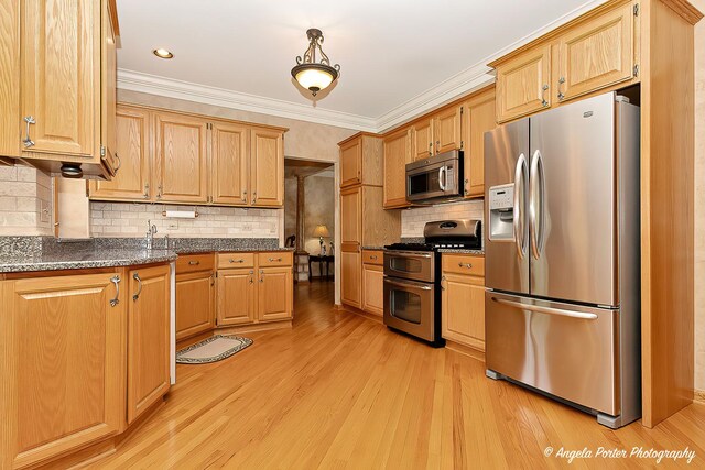 8720 Galleria Ct, Spring Grove, IL 60081 - kitchen with appliances with stainless steel finishes, light wood-style flooring, crown molding, tasteful backsplash, and dark stone counters