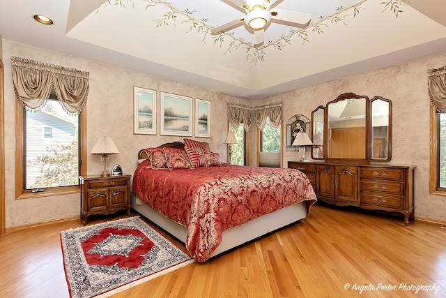 8720 Galleria Ct, Spring Grove, IL 60081 - bedroom featuring baseboards, light wood-type flooring, wallpapered walls, a raised ceiling, and ceiling fan