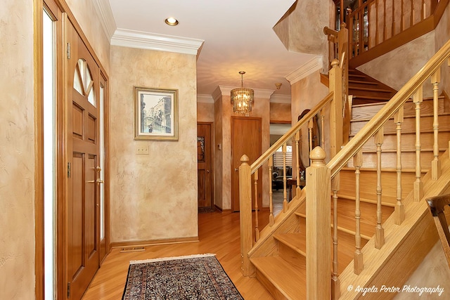 8720 Galleria Ct, Spring Grove, IL 60081 - entryway featuring crown molding, stairs, light wood finished floors, a chandelier, and a textured wall