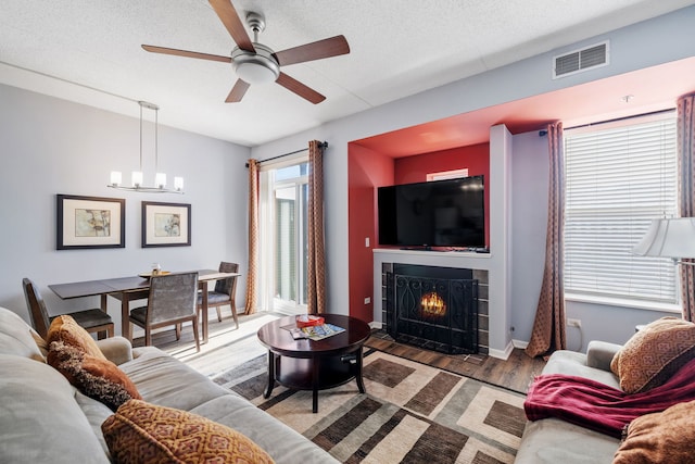 400 Village Cir Unit 207, Willow Springs, IL 60480 - living room with ceiling fan, a fireplace with flush hearth, wood finished floors, a chandelier, and a textured ceiling