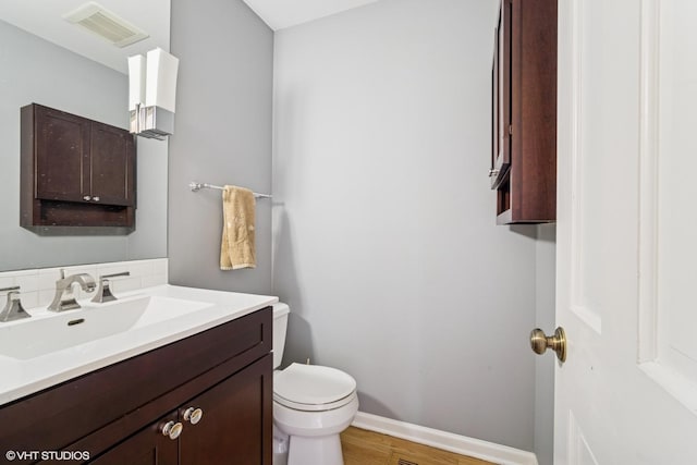 846 Dunhill Dr, Buffalo Grove, IL 60089 - half bathroom featuring toilet, vanity, wood finished floors, and baseboards