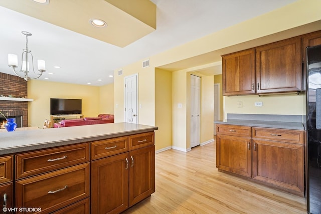 846 Dunhill Dr, Buffalo Grove, IL 60089 - kitchen with light wood finished floors, pendant lighting, a brick fireplace, open floor plan, and brown cabinets