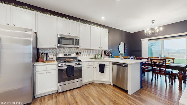 8506 Redbud Ct, Wonder Lake, IL 60097 - kitchen featuring appliances with stainless steel finishes, light wood finished floors, light countertops, a chandelier, and tasteful backsplash