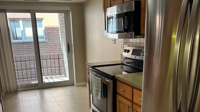 828 Graceland Ave Unit 206, Des Plaines, IL 60016 - kitchen featuring stainless steel appliances, healthy amount of natural light, baseboards, and light tile patterned floors