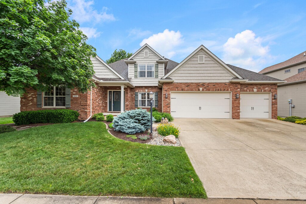 4804 Westborough Dr, Champaign, IL 61822 - view of front of house with a front yard, concrete driveway, a garage, and brick siding