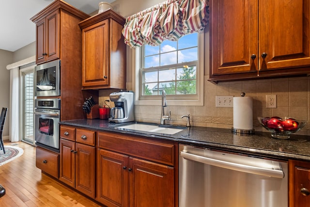 4804 Westborough Dr, Champaign, IL 61822 - kitchen featuring appliances with stainless steel finishes, a sink, tasteful backsplash, light wood-style floors, and brown cabinetry