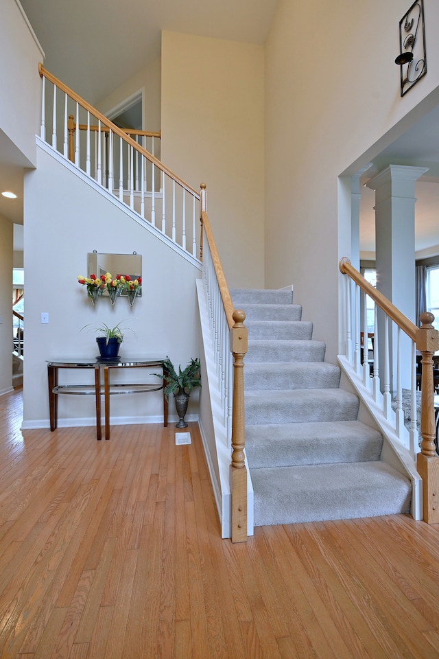 24316 W Bristol Ave, Plainfield, IL 60585 - stairs with wood finished floors, a high ceiling, ornate columns, and baseboards