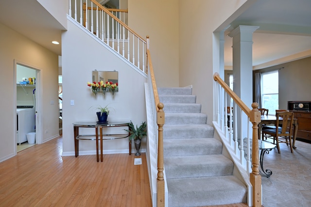 24316 W Bristol Ave, Plainfield, IL 60585 - staircase with washer / clothes dryer, ornate columns, wood finished floors, baseboards, and a towering ceiling