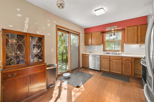 57 Huntcliff Ct, Fox River Grove, IL 60021 - kitchen with appliances with stainless steel finishes, a sink, brown cabinetry, light wood-style floors, and healthy amount of natural light