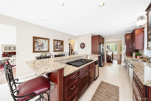 21359 Saddle Ln, Mokena, IL 60448 - kitchen featuring stainless steel fridge with ice dispenser, a kitchen breakfast bar, dark brown cabinets, black gas cooktop, and light tile patterned floors