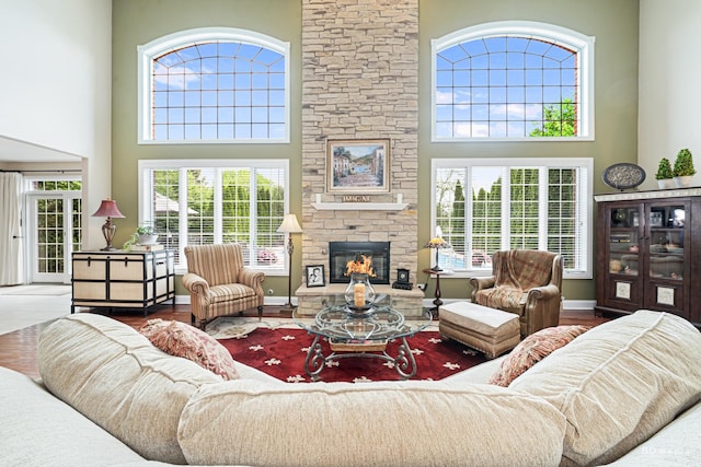 21359 Saddle Ln, Mokena, IL 60448 - living area featuring a towering ceiling, a stone fireplace, wood finished floors, and baseboards