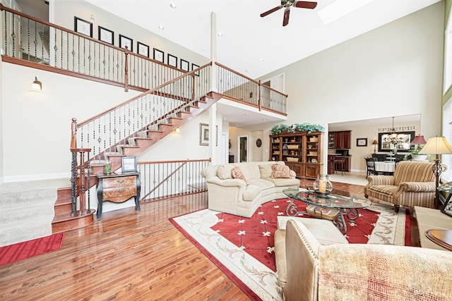 21359 Saddle Ln, Mokena, IL 60448 - living room with a towering ceiling, ceiling fan, wood finished floors, baseboards, and stairs