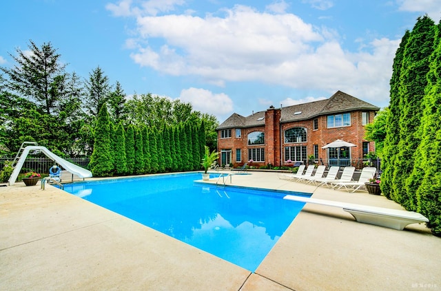 21359 Saddle Ln, Mokena, IL 60448 - swimming pool featuring a water slide, a diving board, a patio, and fence
