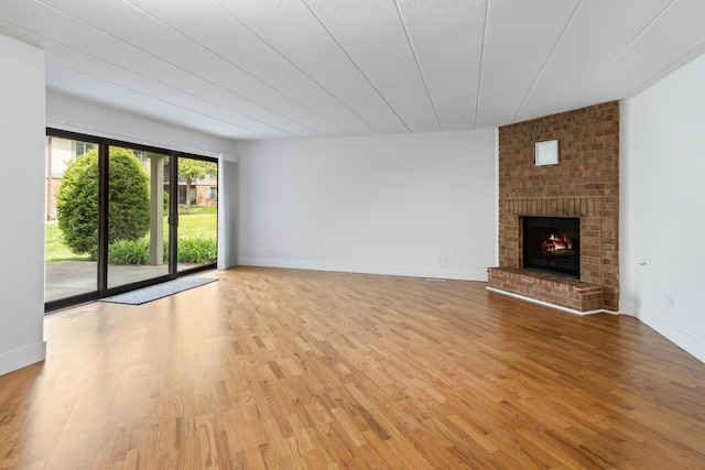 13206 N Country Club Ct Unit 1A, Palos Heights, IL 60463 - unfurnished living room with light wood-style floors, a fireplace, and baseboards