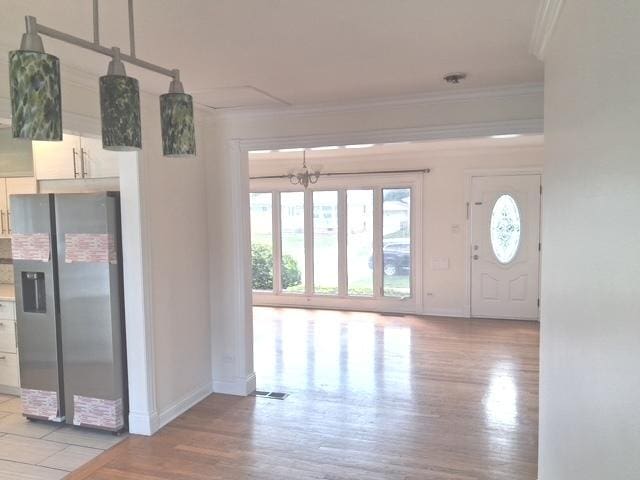 4607 Kolze Ave, Schiller Park, IL 60176 - foyer with crown molding, wood finished floors, baseboards, and a chandelier