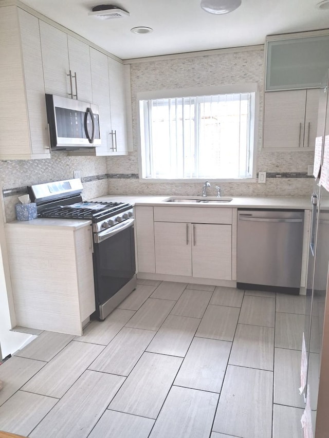 4607 Kolze Ave, Schiller Park, IL 60176 - kitchen featuring appliances with stainless steel finishes, a sink, light countertops, tasteful backsplash, and wood finish floors
