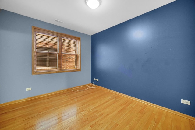 spare room with wood finished floors and baseboards