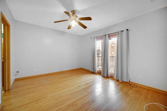 empty room with ceiling fan, light wood-style flooring, and baseboards