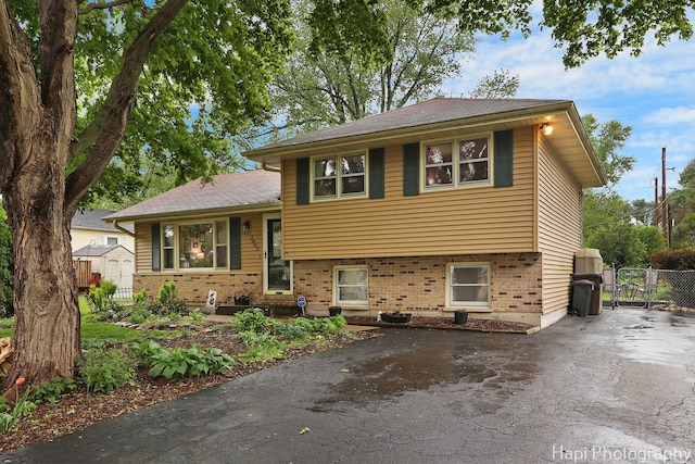 2007 Oak Dr, Mchenry, IL 60050 - tri-level home with asphalt driveway, brick siding, a gate, and a storage shed