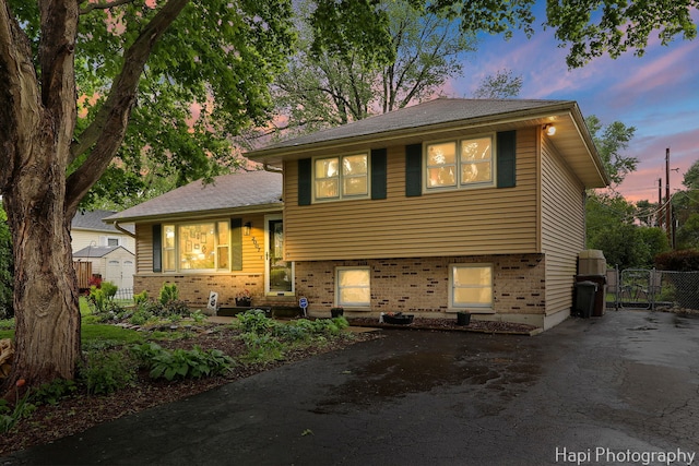 2007 Oak Dr, Mchenry, IL 60050 - split level home with brick siding, a gate, asphalt driveway, and a storage unit