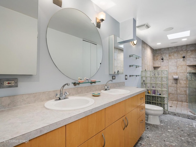 bathroom with toilet, a stall shower, and double vanity