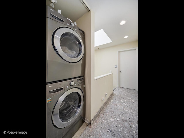 washroom featuring stacked washer / dryer, a skylight, baseboards, and recessed lighting