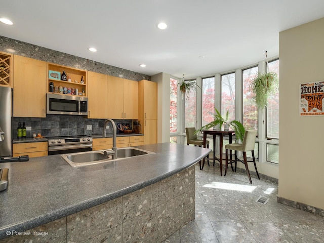 kitchen with stainless steel appliances, a sink, dark countertops, tasteful backsplash, and baseboards