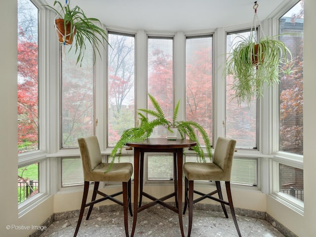 sunroom / solarium with baseboards and healthy amount of natural light