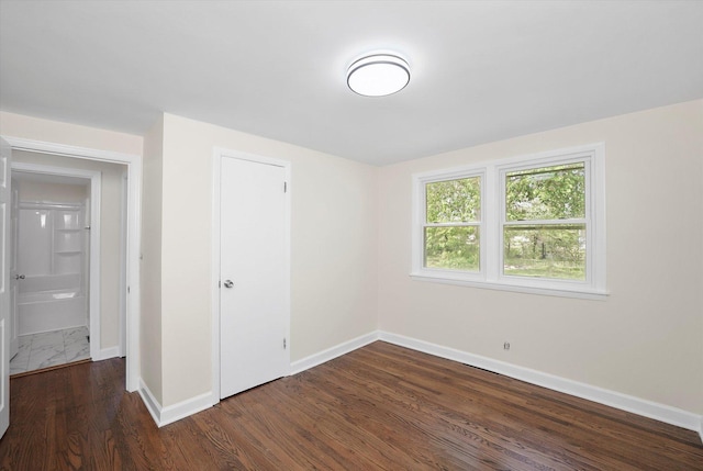 28 Liberty Blvd, Machesney Park, IL 61115 - unfurnished bedroom with baseboards, dark wood-style floors, and a closet