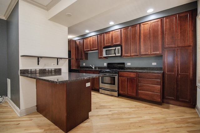 kitchen featuring stainless steel appliances, a peninsula, light wood-type flooring, dark stone counters, and ornamental molding