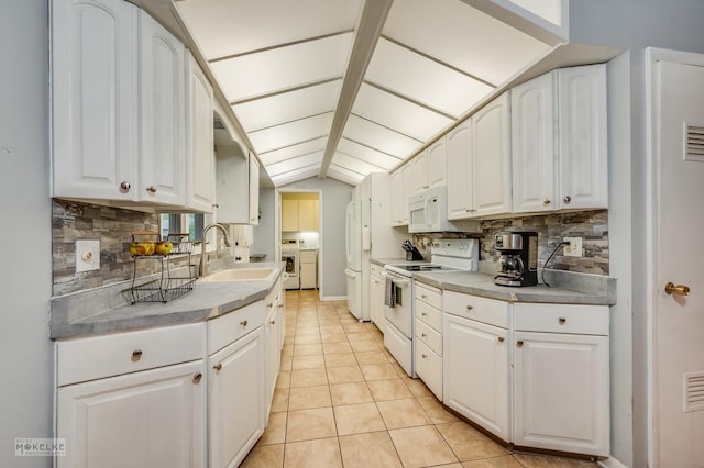 566 Ridge Ave, Elk Grove Village, IL 60007 - kitchen with white appliances, a sink, washing machine and dryer, backsplash, and white cabinetry