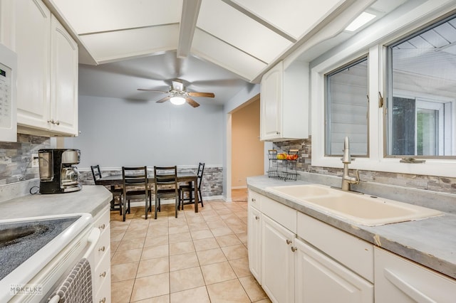 566 Ridge Ave, Elk Grove Village, IL 60007 - kitchen featuring a sink, backsplash, light tile patterned floors, and white cabinetry