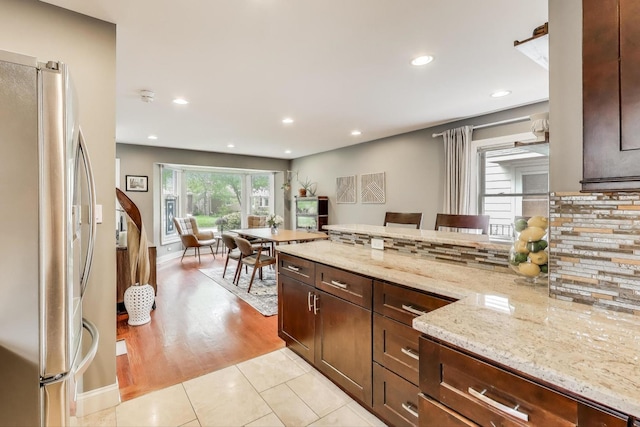 1524 Cleveland St, Evanston, IL 60202 - kitchen with freestanding refrigerator, decorative backsplash, light stone counters, recessed lighting, and dark brown cabinetry