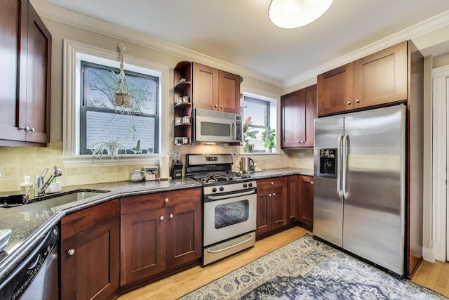 2336 W Roscoe St Unit 3R, Chicago, IL 60618 - kitchen with appliances with stainless steel finishes, dark stone countertops, a sink, ornamental molding, and decorative backsplash