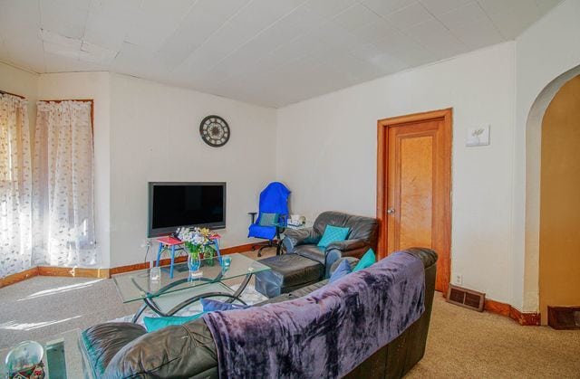 2460 Indiana Ave, Lansing, IL 60438 - living area with arched walkways, carpet, and baseboards
