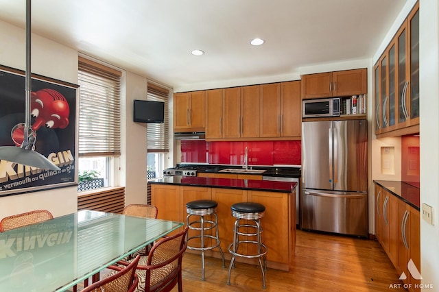 11333 S Langley Ave, Chicago, IL 60628 - kitchen featuring appliances with stainless steel finishes, brown cabinets, light wood-type flooring, ventilation hood, and recessed lighting