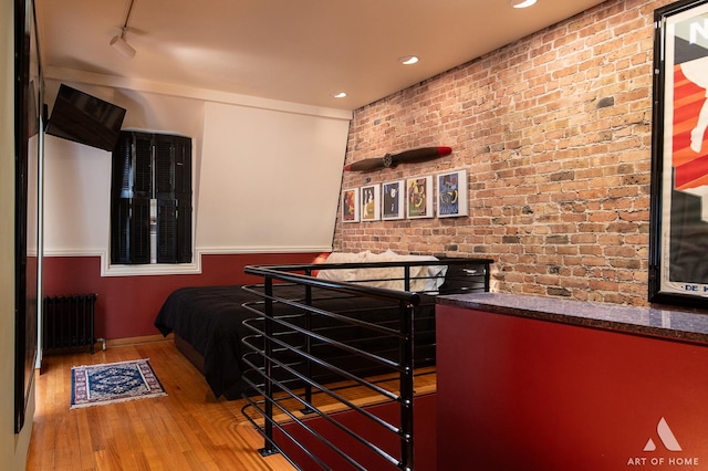 11333 S Langley Ave, Chicago, IL 60628 - kitchen with brick wall, radiator, wood finished floors, dark countertops, and recessed lighting
