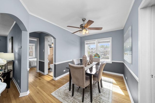 213 N Marion St Unit 2D, Oak Park, IL 60302 - dining space with light wood-style floors, baseboards, crown molding, a ceiling fan, and arched walkways