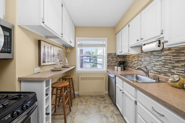213 N Marion St Unit 2D, Oak Park, IL 60302 - kitchen featuring a sink, radiator heating unit, appliances with stainless steel finishes, and white cabinetry