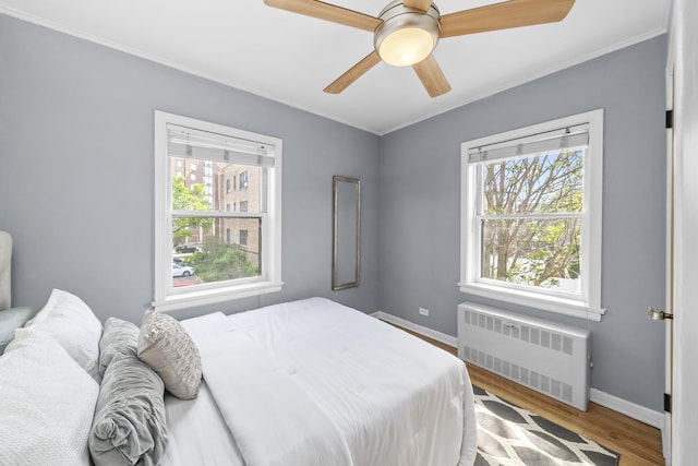 213 N Marion St Unit 2D, Oak Park, IL 60302 - bedroom featuring radiator heating unit, crown molding, baseboards, wood finished floors, and ceiling fan